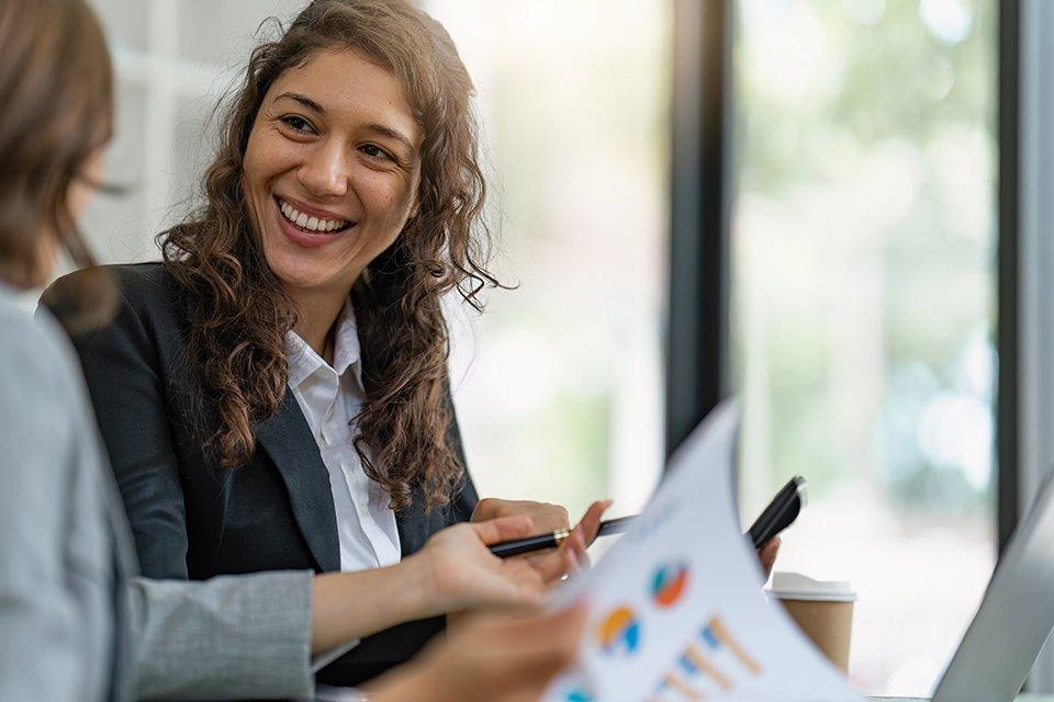 Female accountant smiles at colleague in a business setting.